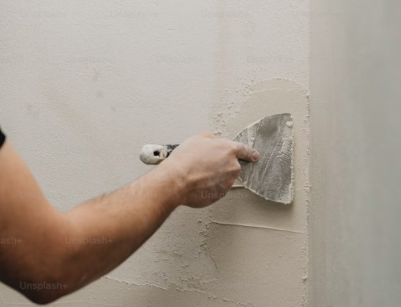 Mano-con-paleta-trabajando-en-pared